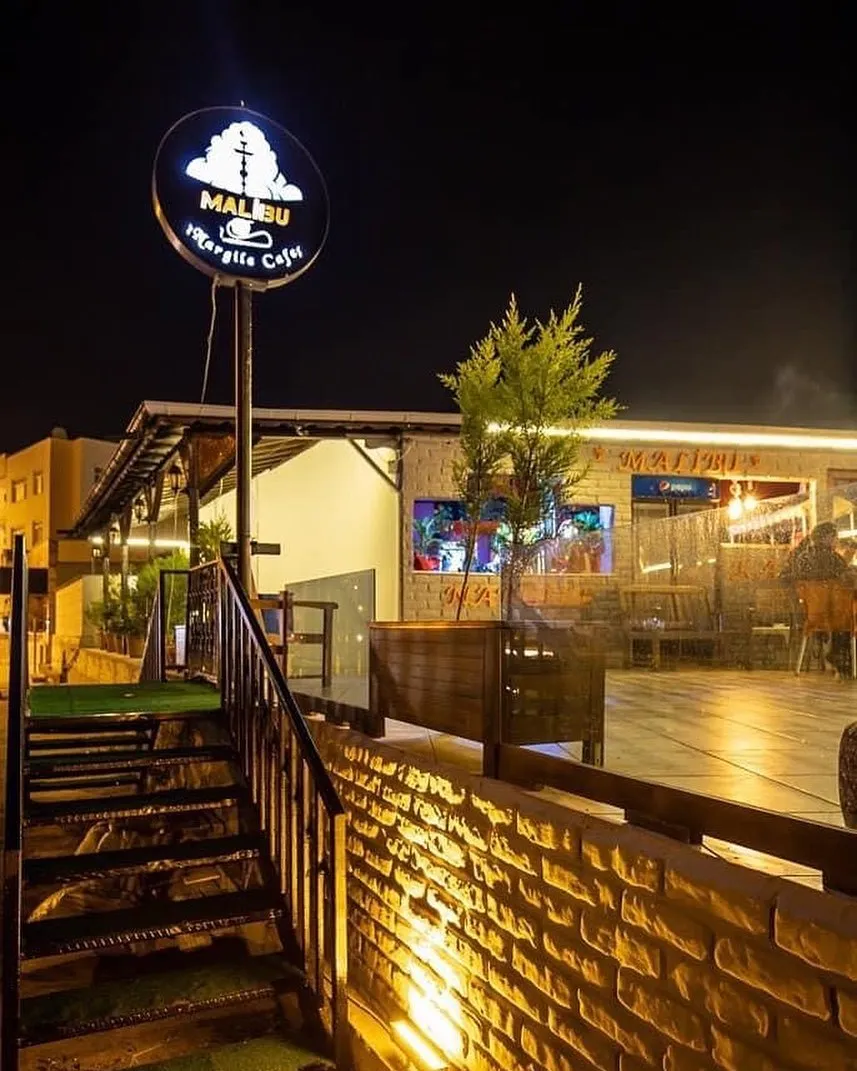 MaliBu Nargile Cafe'nin gece aydınlatılmış girişi ve tabelası